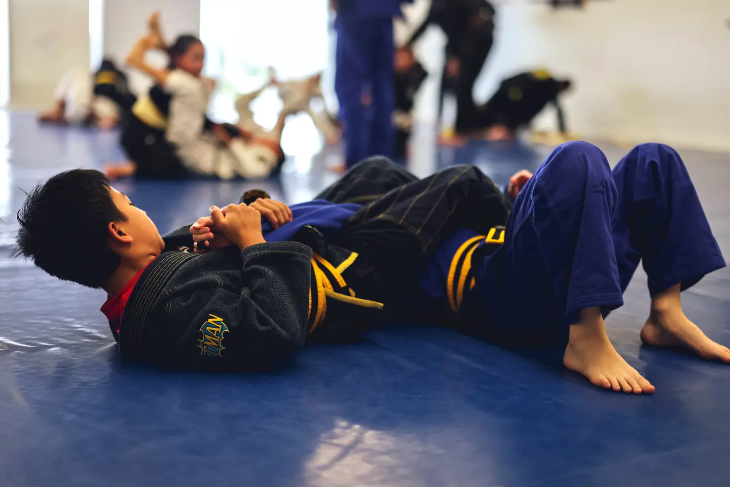 Kinjas teammates practise controlled ground technique together on the blue mats